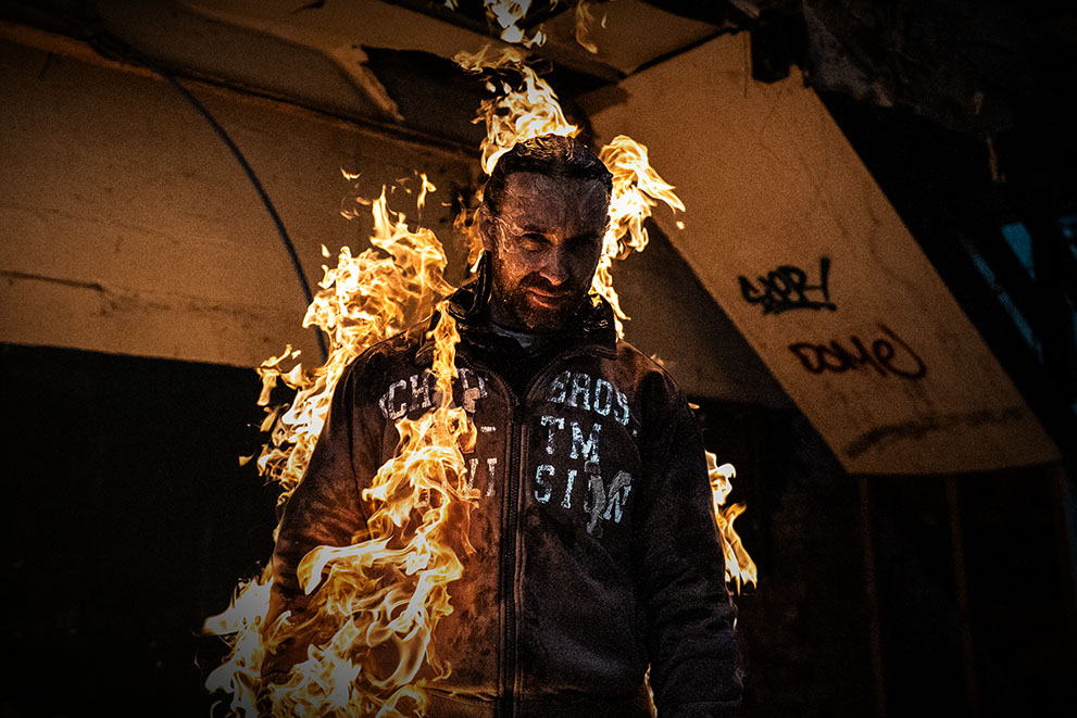 Rob, the owner of Paws in the Pines, mid-stunt performance, engulfed in flame as part of his work as a professional stunt performer.